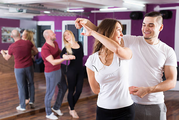 Young couples enjoying of partner dance and smiling indoor